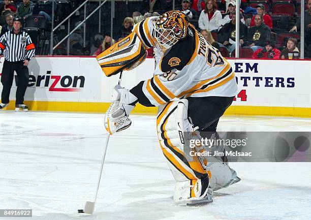 Tim Thomas of the Boston Bruins defends against the New Jersey Devils at the Prudential Center on February 13, 2009 in Newark, New Jersey. The Devils...