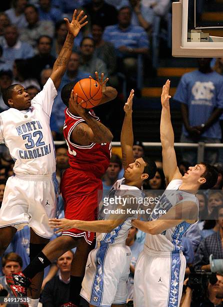 Tracy Smith of the North Carolina State Wolfpack attacks the defense of Ed Davis, Danny Green and Tyler Hansbrough of the North Carolina Tar Heels...