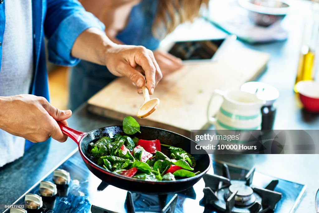 Man frying vegetables