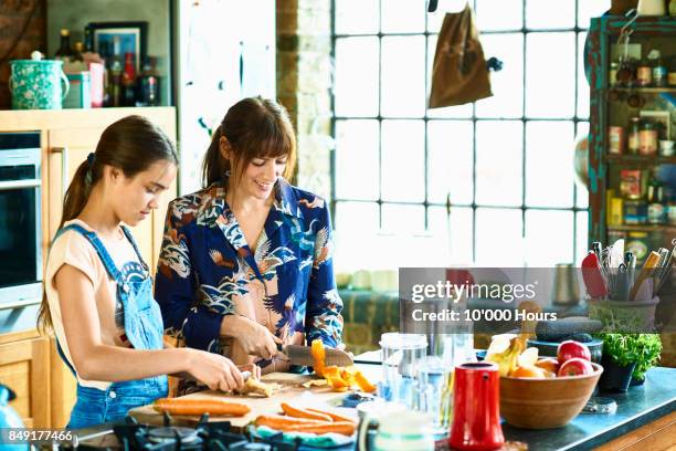 mother and daughter cooking together - knife kitchen stock pictures, royalty-free photos & images