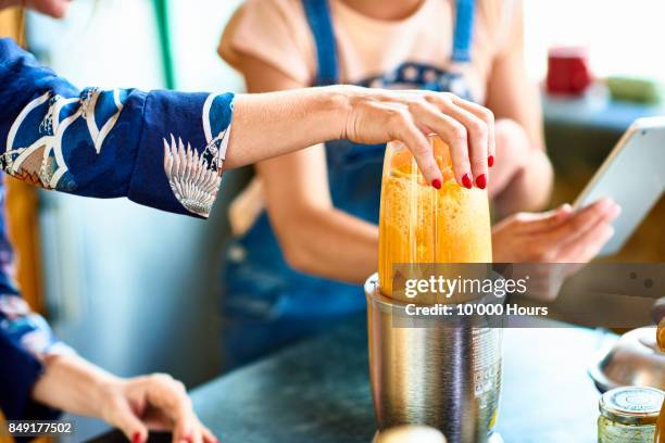 woman preparing smoothie in blender - blender foto e immagini stock