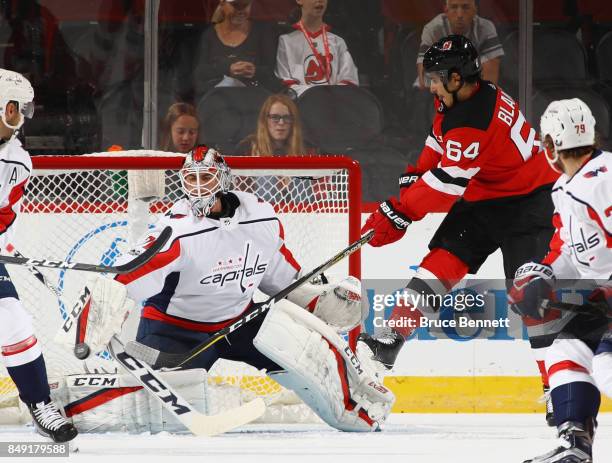 Braden Holtby of the Washington Capitals makes the blocker save as Joseph Blandisi of the New Jersey Devils looks for a rebound during the first...