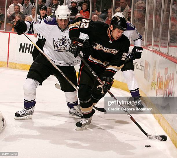 Sean O'Donnell of the Los Angeles Kings reaches for the puck alongside the boards against Travis Moen of the Anaheim Ducks during the game on...