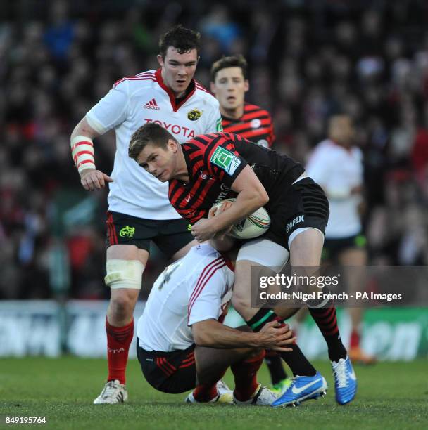 Saracens' Owen Farrell is tackled by Munsters' Doug Howlett during the Heineken Cup, Pool One match at Vicarage Road, London.