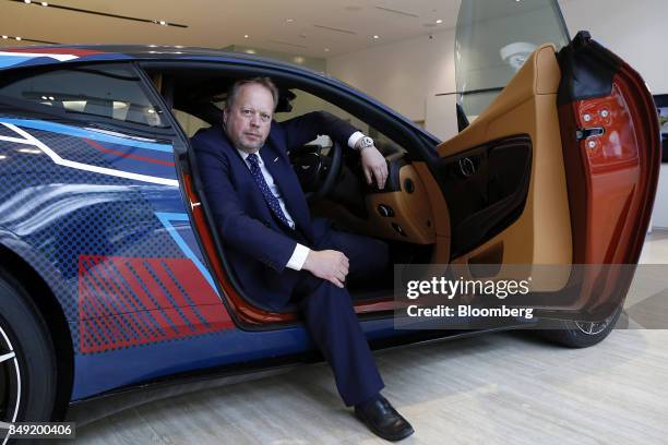 Andy Palmer, chief executive officer of Aston Martin Lagonda Ltd., poses for a photograph while sitting inside a DB11 sports cars after a Bloomberg...