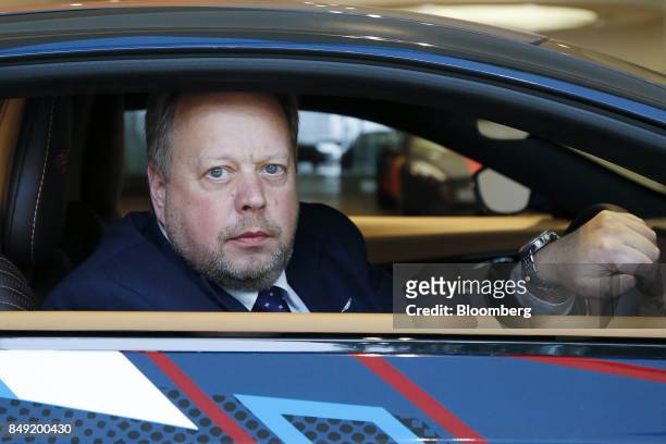Andy Palmer, chief executive officer of Aston Martin Lagonda Ltd., poses for a photograph while sitting inside a DB11 sports cars after a Bloomberg...