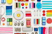 Overhead flat lay of various sewing items on white background