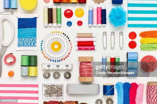 overhead flat lay of various sewing items on white background - button sewing item stock pictures, royalty-free photos & images