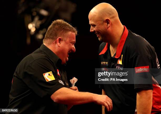 Colin Lloyd and Darin Young joke in their match during the Ladbrokes.com World Darts Championship at Alexandra Palace, London.