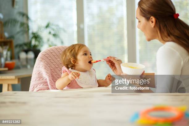 mother feeding the baby - mother baby food stock pictures, royalty-free photos & images