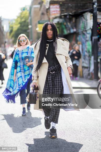 Jan-Michael Quammie wearing black checked pants, trench coat outside Marques Almeida during London Fashion Week September 2017 on September 18, 2017...