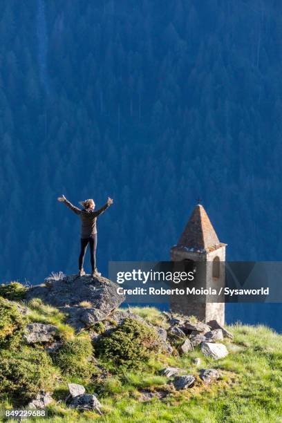 woman admires the old bell tower, san romerio alp, switzerland - brusio grisons stock pictures, royalty-free photos & images