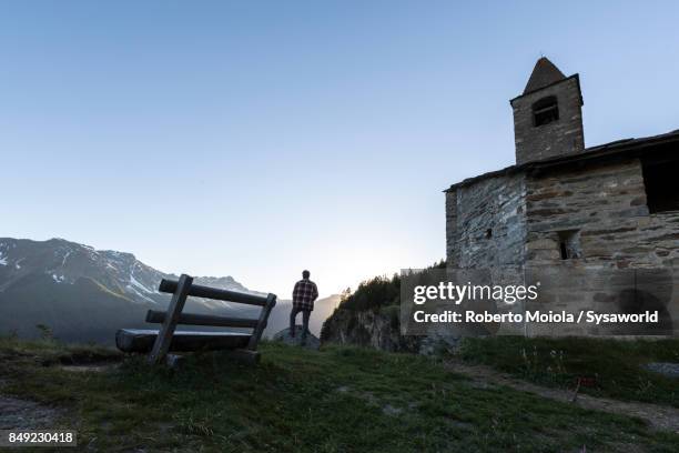 lone man at the old church, san romerio alp, switzerland - brusio grisons stock pictures, royalty-free photos & images