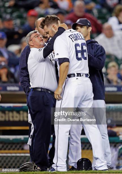 Pitcher Jeff Ferrell of the Detroit Tigers is examined by trainer Kevin Rand, left, and manager Brad Ausmus of the Detroit Tigers after getting hit...