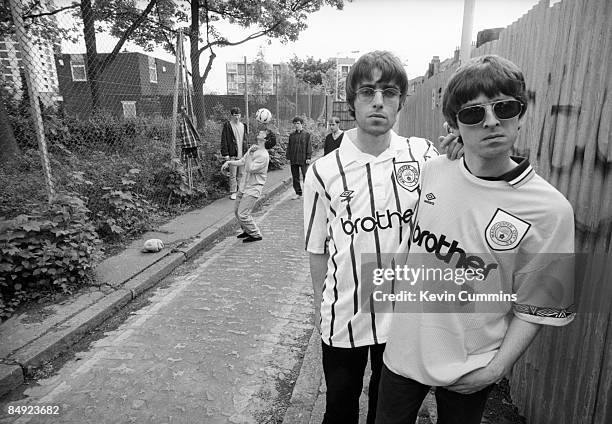 Singer Liam Gallagher and his guitarist brother Noel Gallagher of rock band Oasis, pose in Manchester City football shirts, 9th May 1994. Other band...