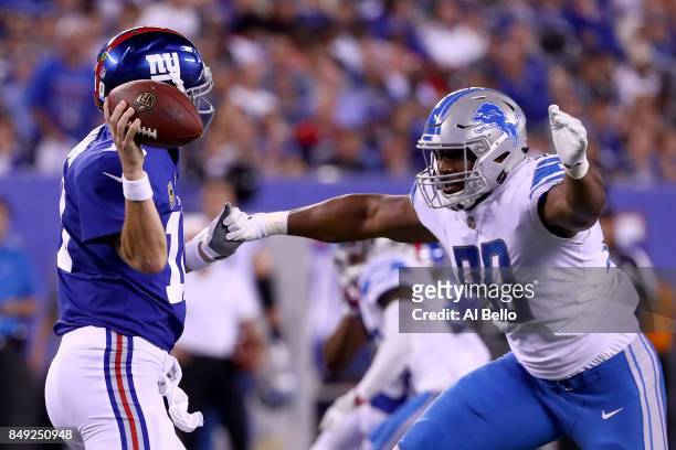 Eli Manning of the New York Giants gets tackled by Cornelius Washington of the Detroit Lions in the fourth quarter during their game at MetLife...
