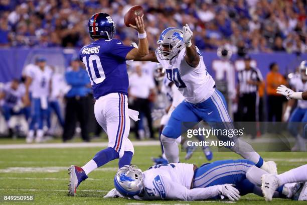 Eli Manning of the New York Giants gets tackled by Cornelius Washington of the Detroit Lions in the fourth quarter during their game at MetLife...