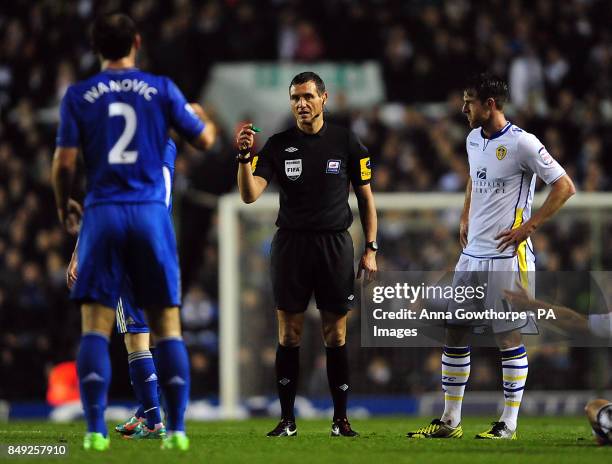 Referee Andre Marriner warns the players