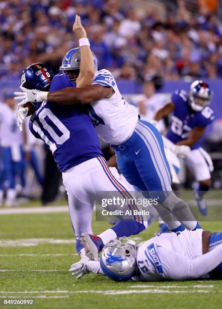 Eli Manning of the New York Giants gets tackled by Cornelius Washington of the Detroit Lions in the fourth quarter during their game at MetLife...