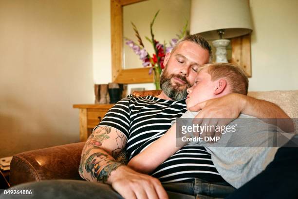 Father and son sleeping on sofa