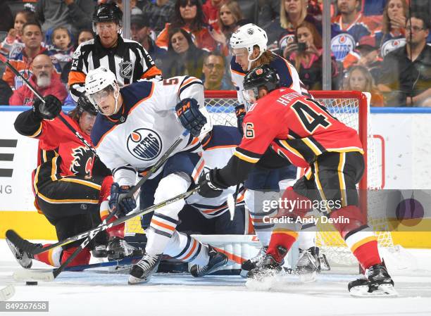 Mark Fayne of the Edmonton Oilers battles for the puck against Marek Hrivik of the Calgary Flames on September 18, 2017 at Rogers Place in Edmonton,...
