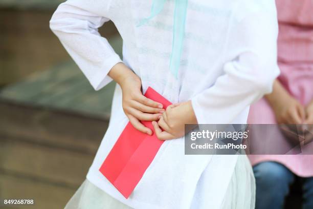 figure of a daughter before showing a letter to my mother - hands behind back stock photos et images de collection