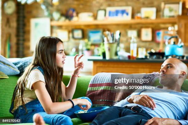 Father and daughter relaxing on sofa