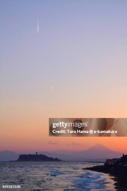 vapor trail on mt. fuji, enoshima island and sagami bay in the sunset - sunset contrail stock pictures, royalty-free photos & images