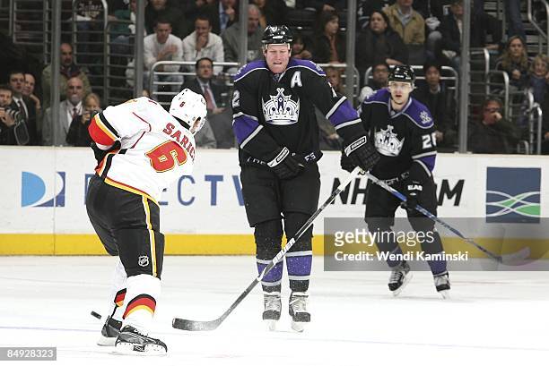 Cory Sarich the Calgary Flames passes the puck into Matt Greene of the Los Angeles Kings on February 12, 2009 at Staples Center in Los Angeles,...