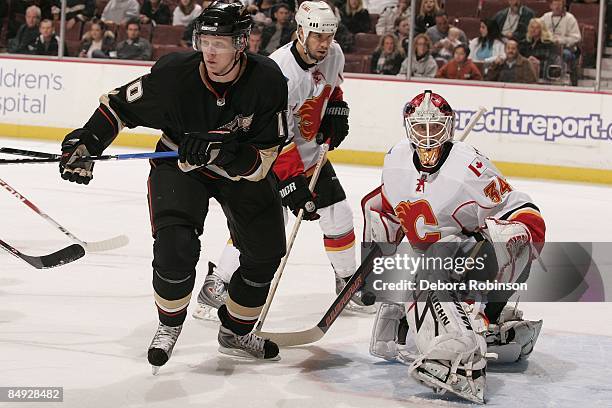 Miikka Kiprusoff of the Calgary Flames defends in the crease against Corey Perry of the Anaheim Ducks during the game on February 11, 2009 at Honda...