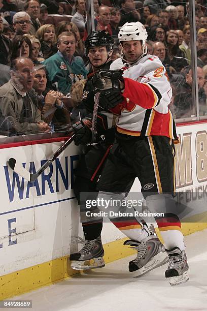 Craig Conroy of the Calgary Flames checks Chris Kunitz of the Anaheim Ducks into the boards during the game on February 11, 2009 at Honda Center in...