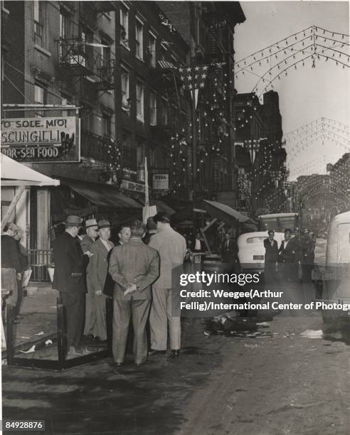 Outside the 'O Sole Mio Scungilli Bar and Seafood Restaurant' on Mulberry Street, detectives and police officers gather at the site of a murder where...