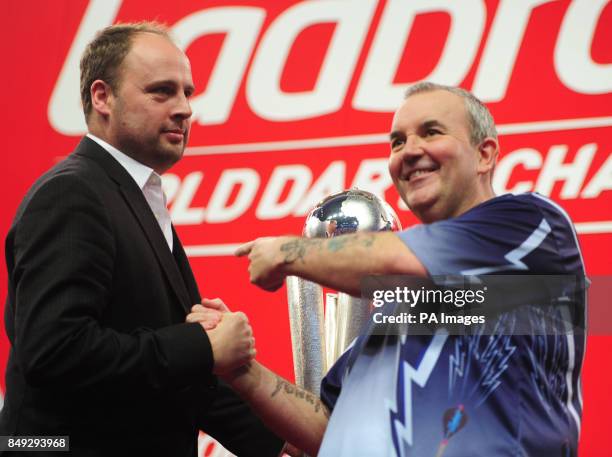 Phil Taylor is congratulated by the late Sid Waddell's son Dan after winning the Ladbrokes.com World Darts Championship Final at Alexandra Palace,...