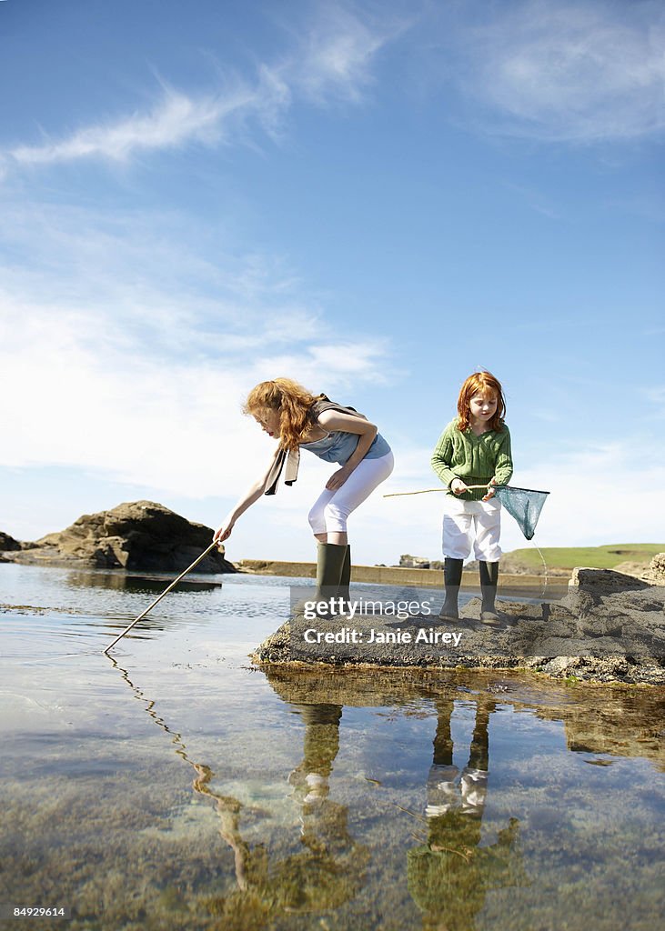 2 girls fishing in rock pool