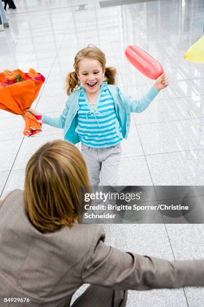 girl holding flowers running at woman - reunite stock pictures, royalty-free photos & images