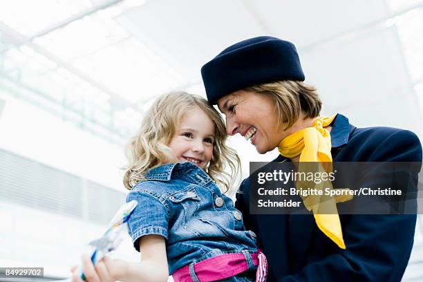 stewardess holding child in her arms - crew foto e immagini stock