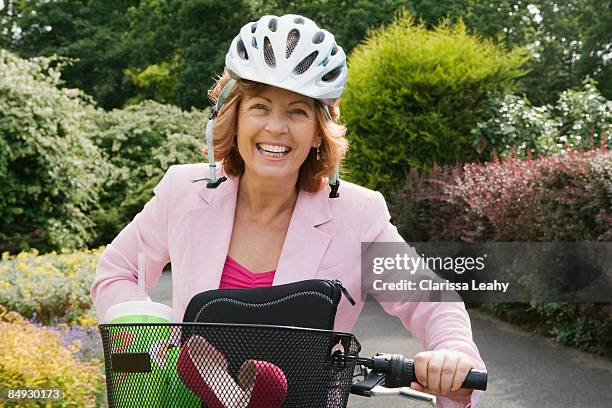 woman wearing helmet on bicycle - midlife crisis stock pictures, royalty-free photos & images