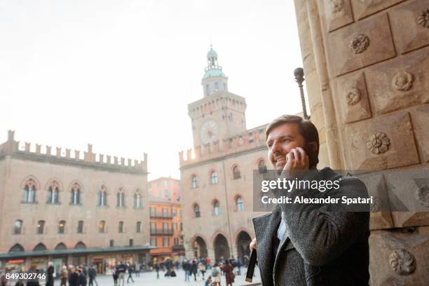 businessman talking on the cell phone at the main square of a european city - main smartphone fotografías e imágenes de stock