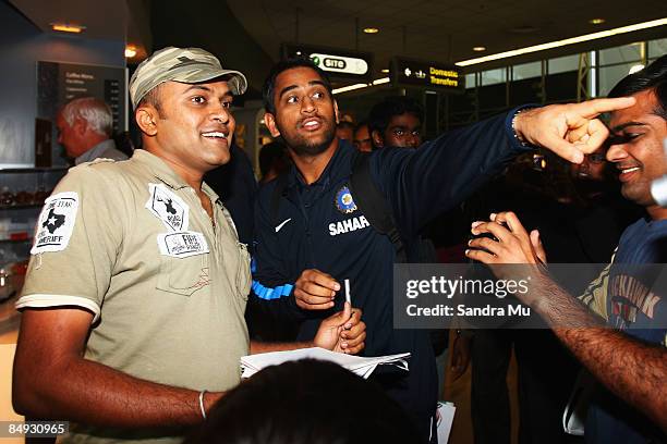 Dhoni of India points out Sachin Tendulkar to deter the fans at the arrivals hall as the Indian cricket team arrive at Auckland International Airport...