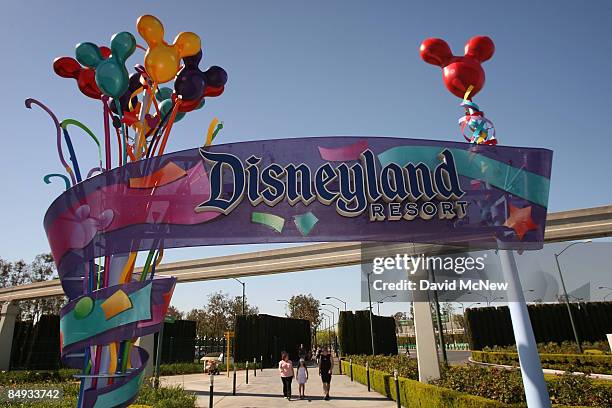 Pedestrians walk near the entrance to Disneyland Resort on February 19, 2009 in Anaheim, California. With the worsening economy, declining attendance...