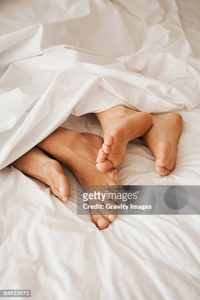 couple's feet in bed - girlfriend feet stock pictures, royalty-free photos & images