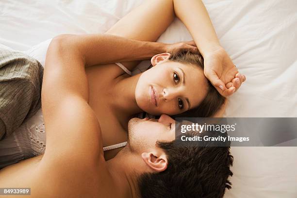 close-up of couple in bed, view from above - couple cuddling in bed stock pictures, royalty-free photos & images