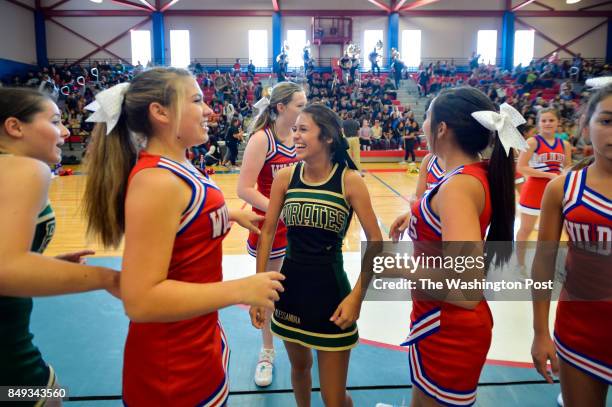 Rockport-Fulton High School cheerleader Alessandra Silva, center, visits with Gregory-Portland High School cheerleaders as they prepare for a joint...