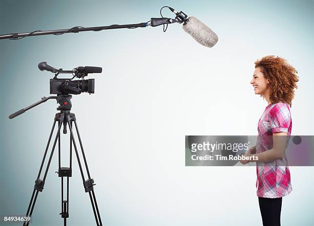 young tv presenter doing a piece to camera - film studio stockfoto's en -beelden