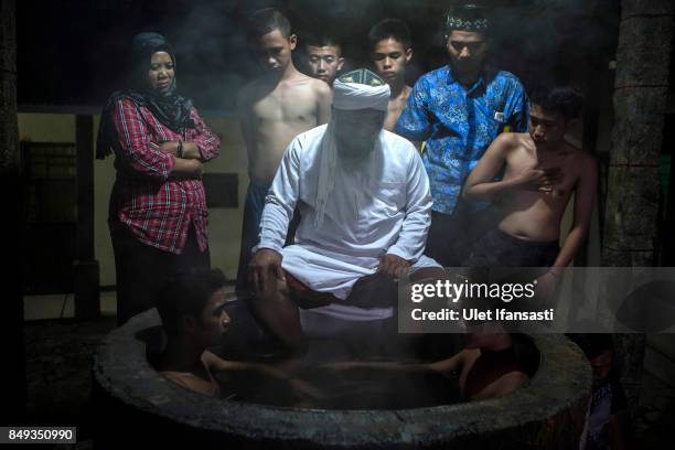 Ustad Ahmad Ischsan Maulana, the head of Nurul Ichsan Al Islami traditional rehabilitation centre, prays with recovering drug addicts who are...