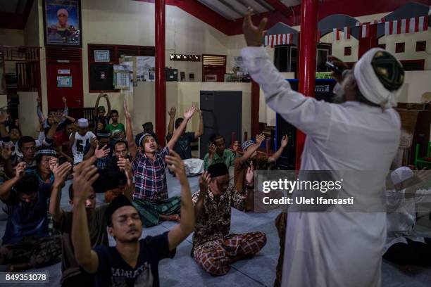 Ustad Ahmad Ischsan Maulana, the head of Nurul Ichsan Al Islami traditional rehabilitation centre, prays with recovering drug addicts during a prayer...