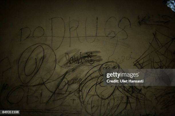 Graffiti of recovering drug addicts is seen on the wall of Nurul Ichsan Al Islami traditional rehabilitation centre on September 16, 2017 in...