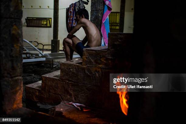 Recovering drug addict waits for his herbal hot water immersion treatment by the head of rehabilitation centre, Ustad Ahmad Ischsan Maulana at the...