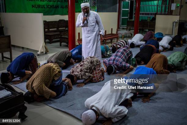 Ustad Ahmad Ischsan Maulana, the head of Nurul Ichsan Al Islami traditional rehabilitation centre, prays with recovering drug addicts during a prayer...