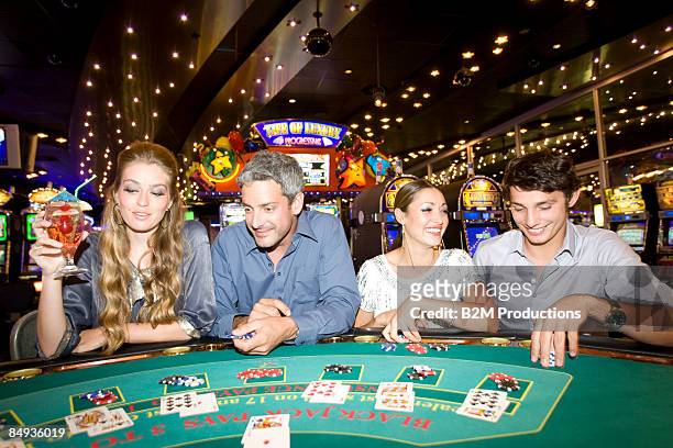 friends playing in casino - casino poker stock pictures, royalty-free photos & images